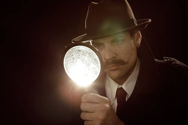 Private investigator looking through a magnifying glass How Much Does a Private Investigator Cost