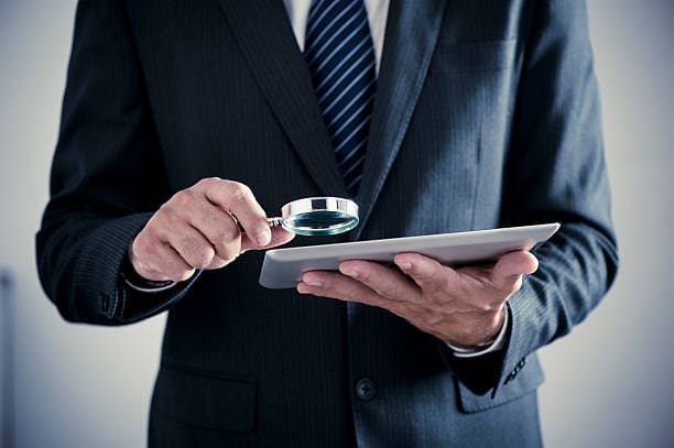 man looking at a paper Hire Investigator